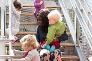Inakindergarten, Kita Dresdener Strasse,, Gruppe mit Erzieherin auf Treppe